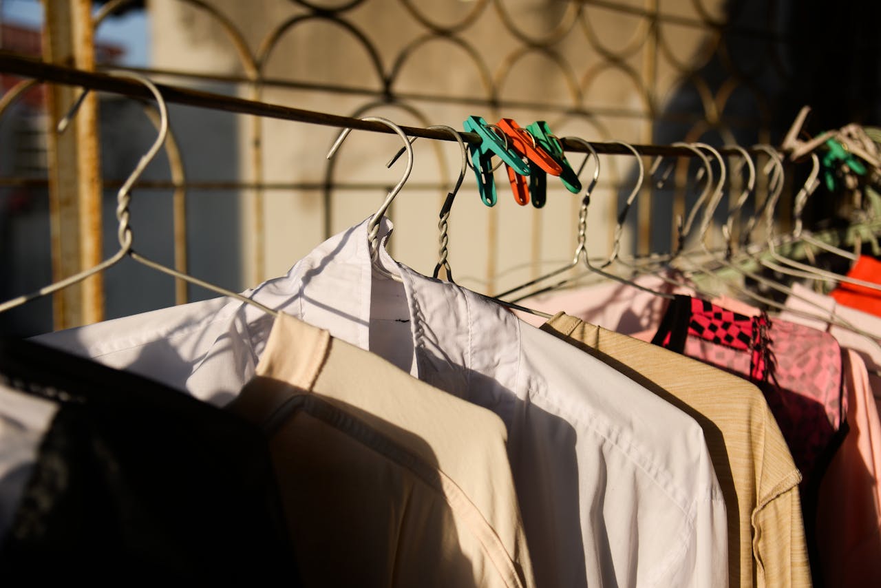 Clothes drying on a sunny outdoor rack with vibrant colors and shadows.